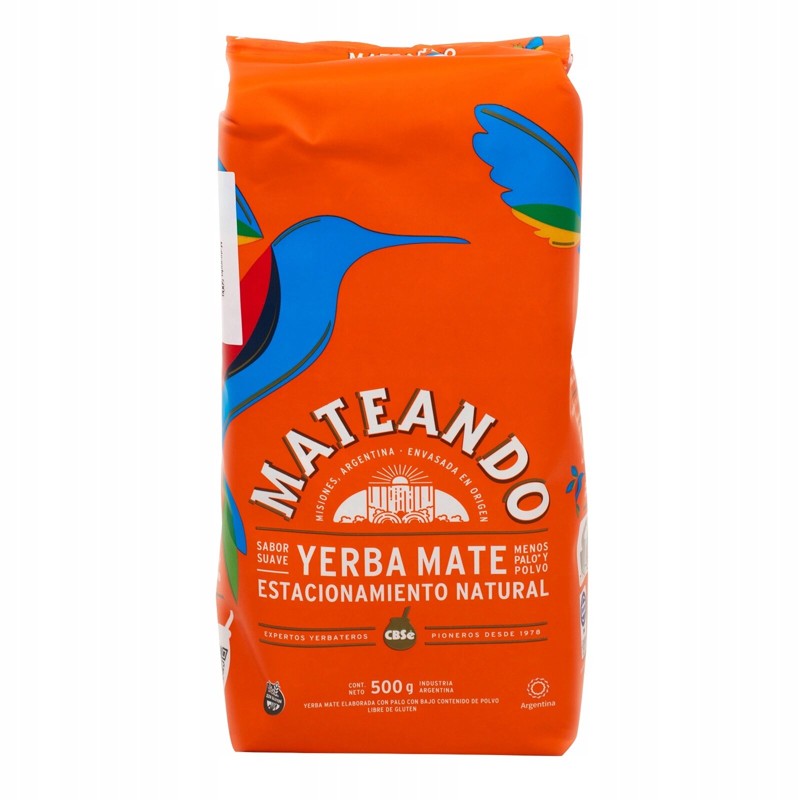 Opakowanie Yerba Mate Mateando CBSe 0,5kg w kolorze pomarańczowym z kolorowym motywem ptaka. Na opakowaniu widnieje tekst: \'Yerba Mate Estacionamiento Natural, Sabor Suave, Menos Palo y Polvo, 500 g\'.