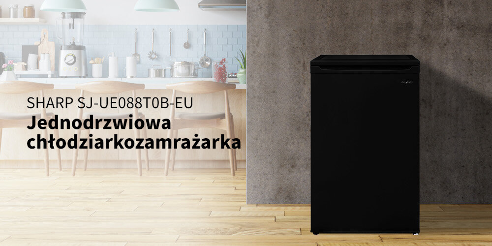 Czarna lodówka stoi na drewnianej podłodze, obok widoczna jest kuchnia z jasnymi meblami. Na obrazie znajduje się tekst: \'SHARP SJ-UE088T0B-EU Jednodrzwiowa chłodziarkozamrażarka\'.