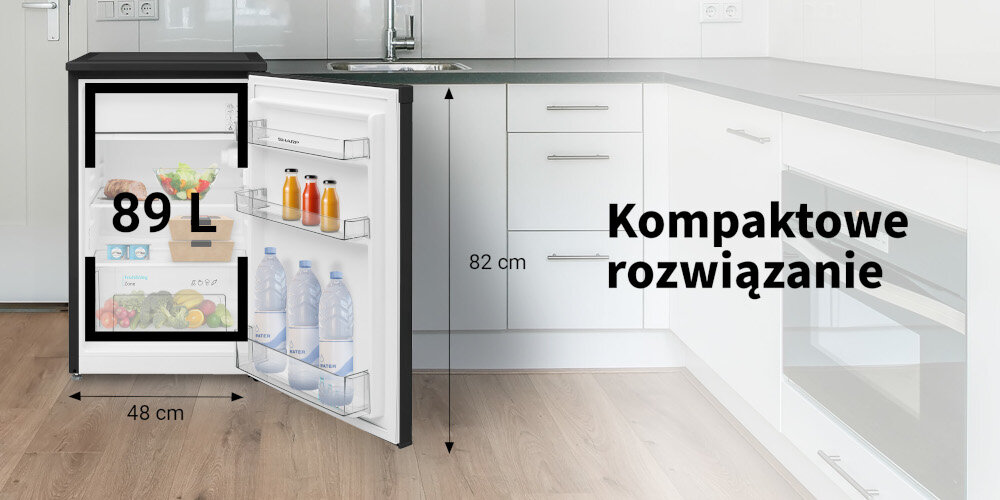 Lodówka o pojemności 89 L z otwartymi drzwiami, ukazująca wnętrze z produktami spożywczymi. Obok lodówki widoczny jest napis \'Kompaktowe rozwiązanie\' oraz wymiary 82 cm i 48 cm.
