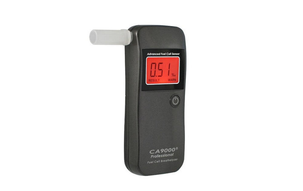 Na obrazie widoczny jest alkomat z wyświetlaczem pokazującym wynik 0.51 ‰ oraz napisami \'Advanced Fuel Cell Sensor\' i \'CA9000® Professional Fuel Cell Breathalyzer\'.