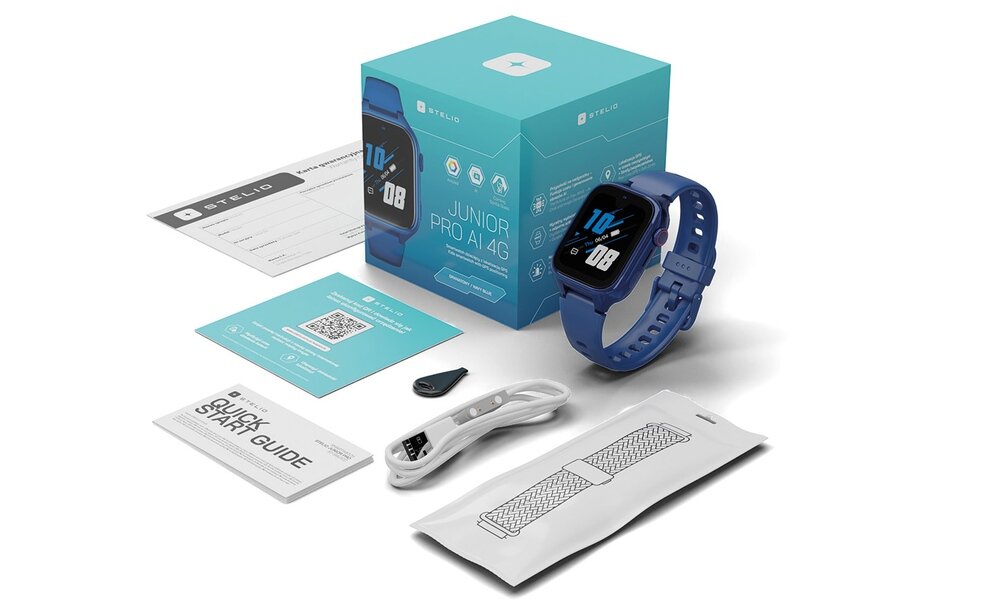 Na obrazie znajduje się smartwatch w kolorze granatowym z wyświetlaczem pokazującym godzinę 10:10, obok niego pudełko z napisem \'JUNIOR PRO AI 4G\' oraz akcesoria takie jak przewód do ładowania, instrukcja obsługi i karta gwarancyjna.