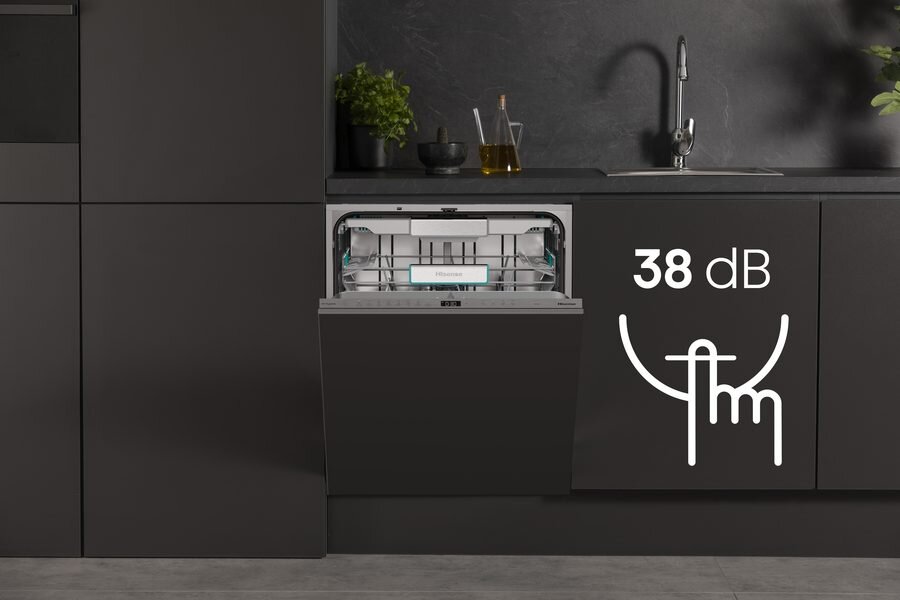 Otwarta zmywarka w ciemnej zabudowie kuchennej, obok oznaczenie 38 dB z symbolem cichej pracy