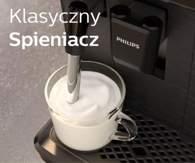 Na obrazie widoczny jest ekspres do kawy z logo PHILIPS, z którego spieniacz wytwarza piankę w szklance. Obok znajduje się tekst: \'Klasyczny Spieniacz\'.