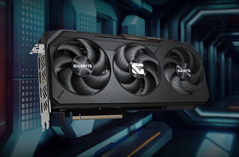 Karta graficzna GIGABYTE Radeon RX 9070 GRE Gaming OC Karta graficzna pokazana z przodu pod lekkim kątem, z trzema wentylatorami usytuowanymi w podłużnej obudowie, zamontowana na tle futurystycznego panelu