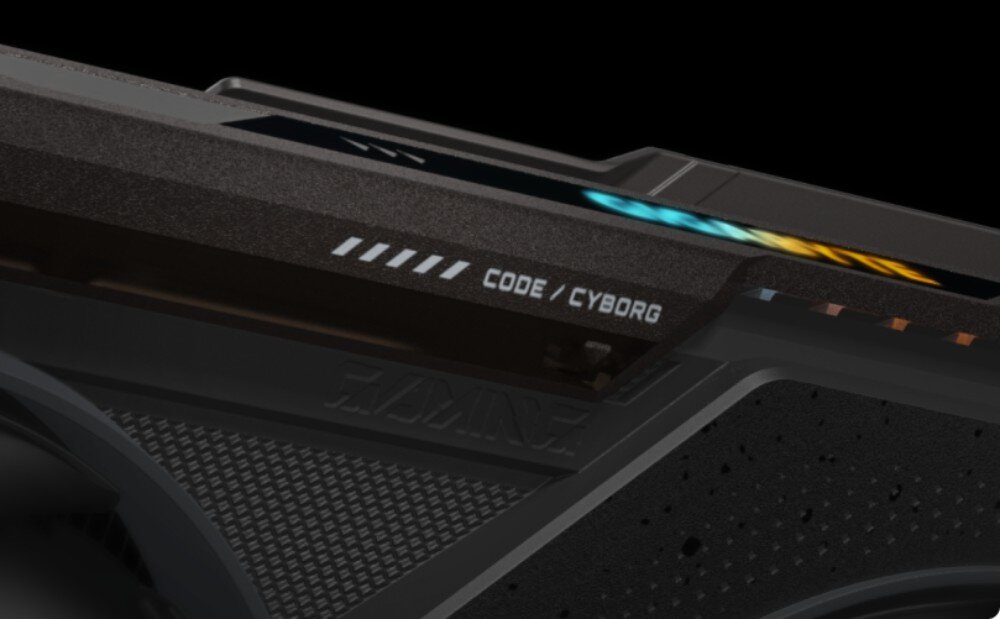Karta graficzna GIGABYTE Radeon RX 9070 GRE Gaming OC Zbliżenie na krawędź obudowy karty graficznej z umieszczonym na niej napisem 'CODE / CYBORG' oraz elementem podświetlenia