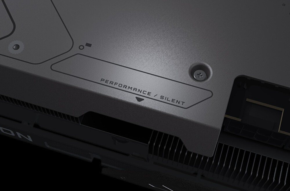 Karta graficzna GIGABYTE Radeon RX 9070 GRE Gaming OC Zbliżenie na metalową powierzchnię z oznaczeniem 'PERFORMANCE / SILENT' i małą strzałką wskazującą przełącznik trybu działania