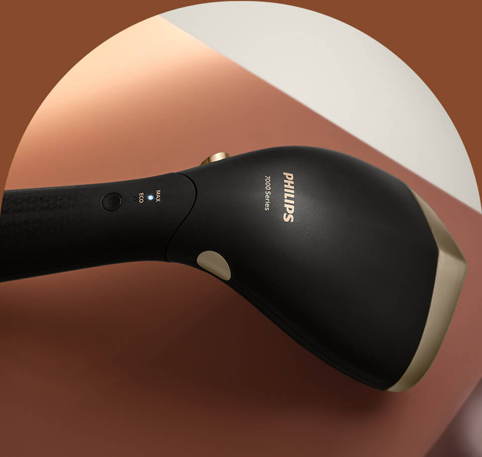 Czarna parownica do ubrań z widocznym logo \'PHILIPS 7000 Series\' na uchwycie. Obok znajduje się przycisk z oznaczeniami \'MAX\' i \'ECO\'.