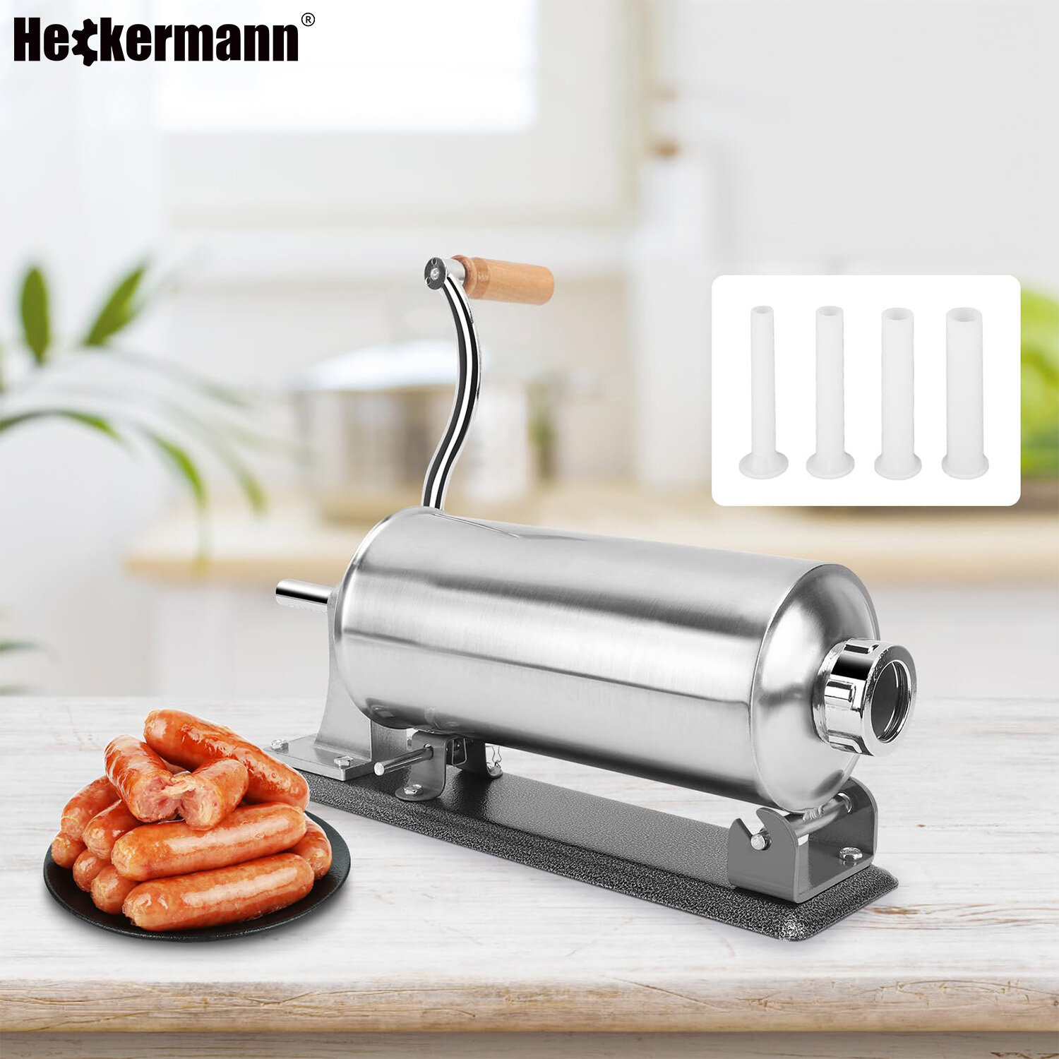 Na obrazie widoczna jest metalowa nadziewarka do kiełbas z drewnianą rączką, obok której leży talerz z kiełbasami. W tle znajduje się logo \'Heckermann\' oraz cztery plastikowe końcówki do nadziewarki.