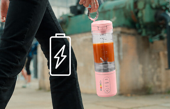 Osoba trzyma Blender personalny iCoook GO MBL-IC-01/B w ręce za magnetyczny ring. Ikona baterii z błyskawicą.