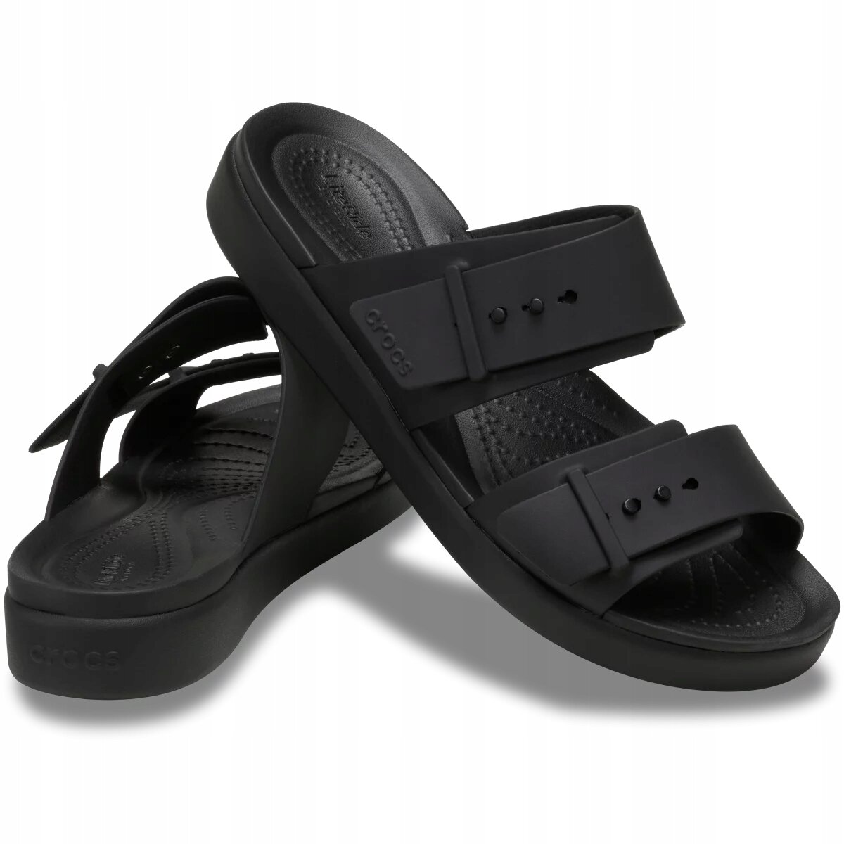 Czarne sandały z dwoma szerokimi paskami i klamrami, z widocznym logo \'crocs\' na jednym z pasków. Podeszwa jest gruba i ma teksturowaną powierzchnię wewnętrzną.