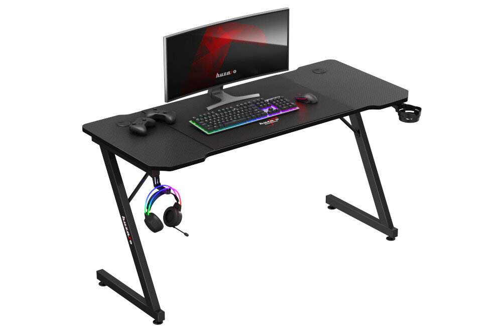 Czarne biurko gamingowe z monitorem, klawiaturą, myszką i kontrolerem do gier. Na biurku widoczne jest logo \'huzaro\'.
