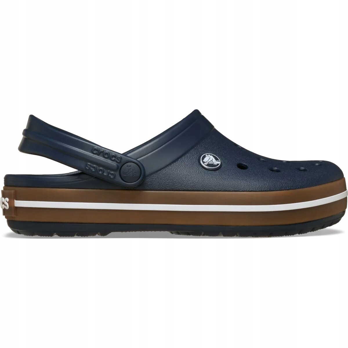 Na obrazie widoczny jest pojedynczy chodak w kolorze granatowym z brązową podeszwą i białym paskiem. Na pasku znajduje się logo \'crocs\'.