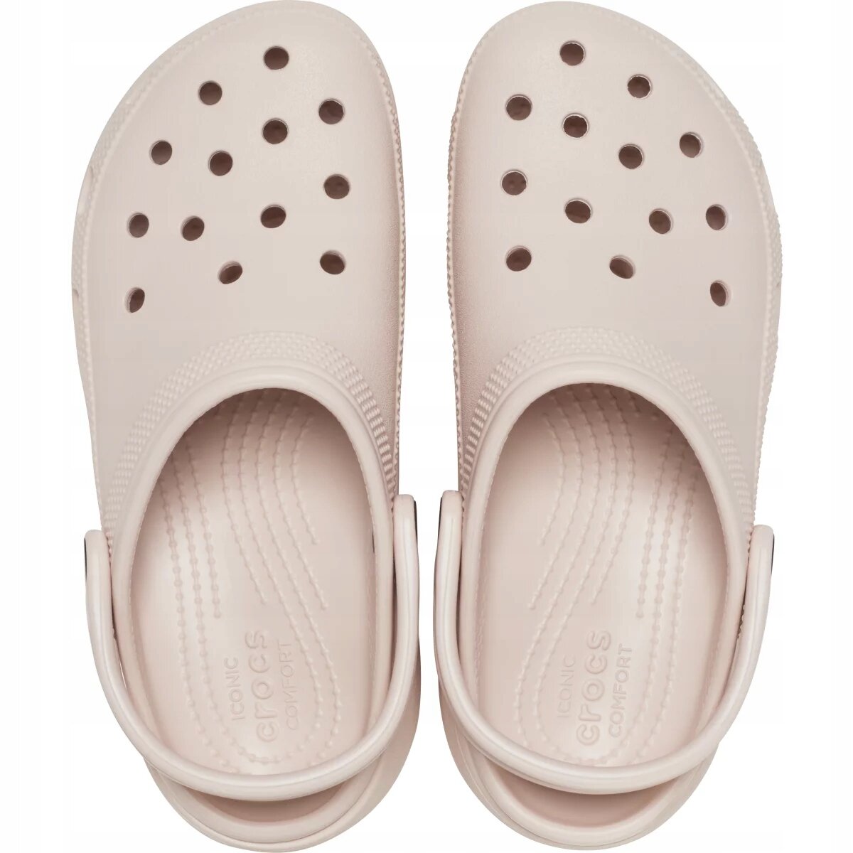 Para jasnoróżowych chodaków z otworami wentylacyjnymi na górze i paskiem na piętę. Wewnątrz widoczny napis: \'ICONIC crocs COMFORT\'.
