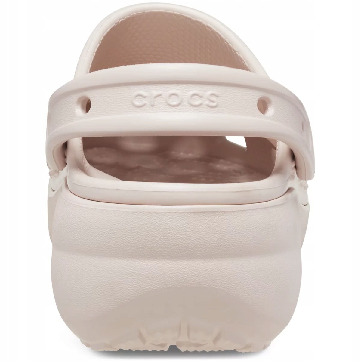 Zdjęcie przedstawia tył jasnoróżowego buta typu chodak z widocznym paskiem na pięcie. Na pasku znajduje się wytłoczony napis \'crocs\'.