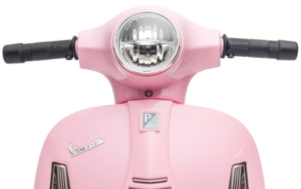 Różowy przód elektrycznego skutera z okrągłym reflektorem i logo \'Vespa\'.