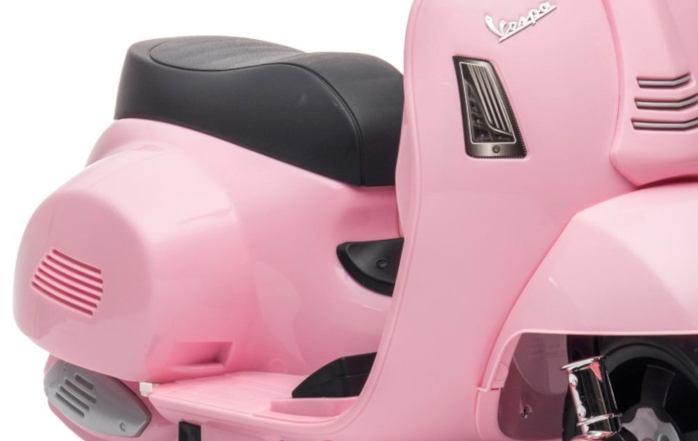 Różowy elektryczny skuter z czarnym siedzeniem i logo \'Vespa\' na boku. Skuter ma elegancki, zaokrąglony design z widocznymi detalami przy tylnym kole.