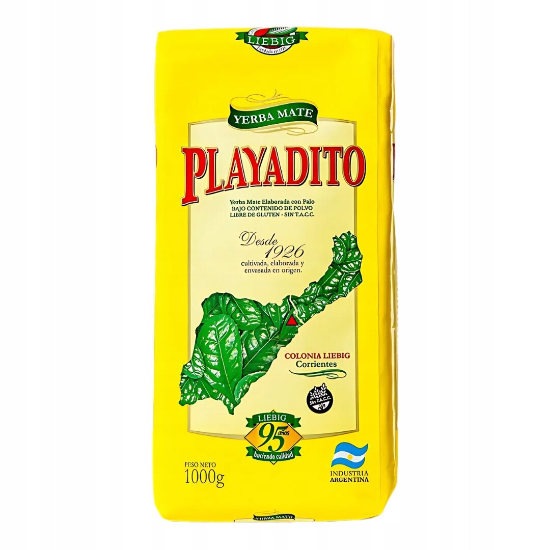 Opakowanie Yerba Mate Playadito Elaborada Con Palo Tradicional 1000g w żółtym kolorze z dużym czerwonym napisem \'PLAYADITO\'. Widoczne są również zielone liście oraz teksty informacyjne, takie jak \'Desde 1926\' i \'Industria Argentina\'.