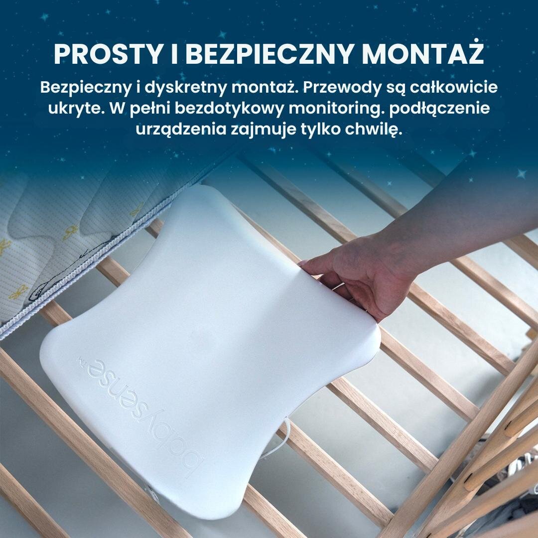 Osoba montuje biały monitor oddechu na drewnianym stelażu łóżeczka. Na górze obrazu widoczny jest tekst: \'PROSTY I BEZPIECZNY MONTAŻ Bezpieczny i dyskretny montaż. Przewody są całkowicie ukryte. W pełni bezdotykowy monitoring, podłączenie urządzenia zajmuje tylko chwilę.\'.