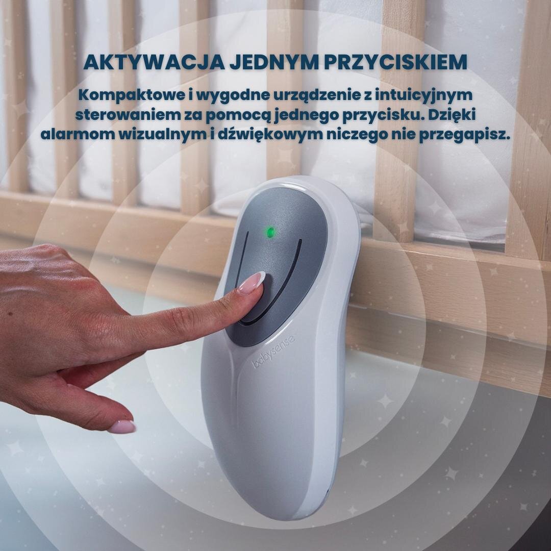 Osoba naciska przycisk na urządzeniu Babysense, które jest umieszczone obok łóżeczka. Na górze widoczny jest tekst: \'AKTYWACJA JEDNYM PRZYCISKIEM Kompaktowe i wygodne urządzenie z intuicyjnym sterowaniem za pomocą jednego przycisku. Dzięki alarmom wizualnym i dźwiękowym niczego nie przegapisz.\'