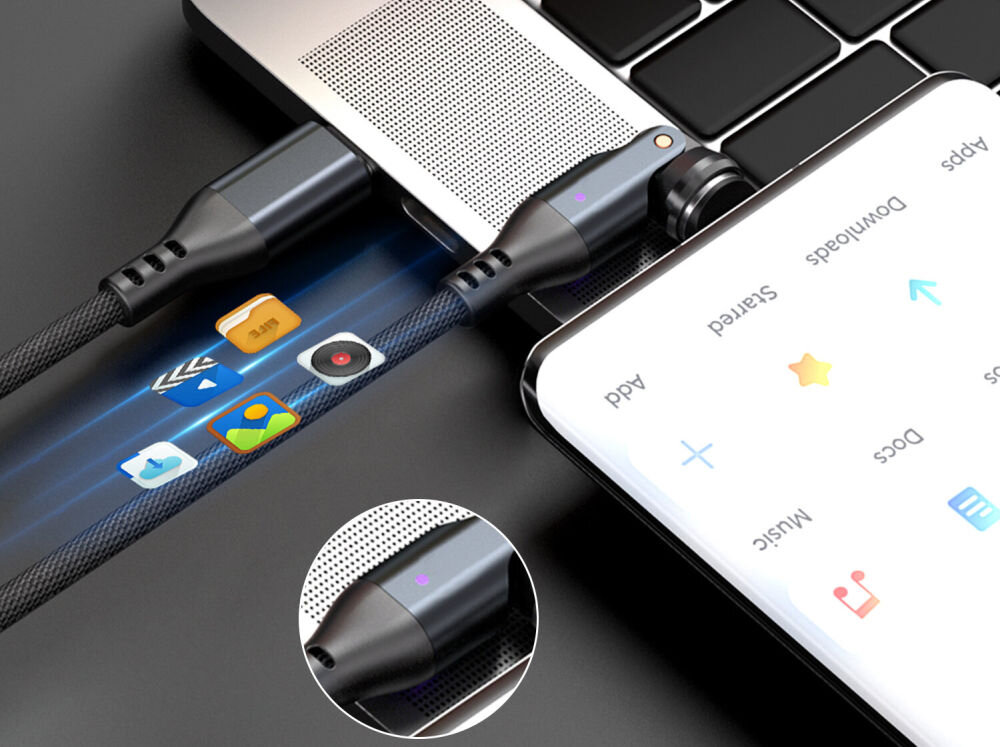 Na obrazie widać czarny kabel magnetyczny USB-C podłączony do laptopa i smartfona. Na ekranie smartfona widoczne są ikony aplikacji oraz teksty: \'Apps\', \'Download\', \'Docs\', \'Music\'.