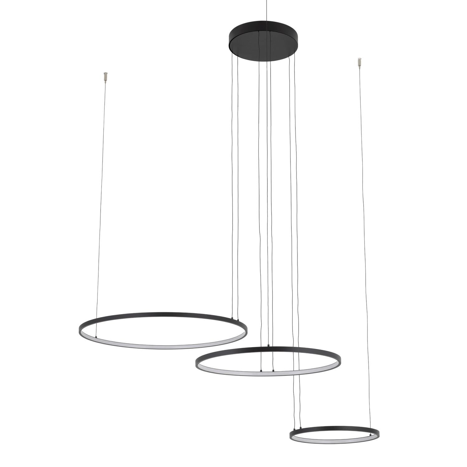 Na obrazie widoczna jest nowoczesna lampa wisząca z trzema okrągłymi, czarnymi pierścieniami zawieszonymi na cienkich przewodach. Każdy pierścień jest na innej wysokości, tworząc efekt kaskadowy.