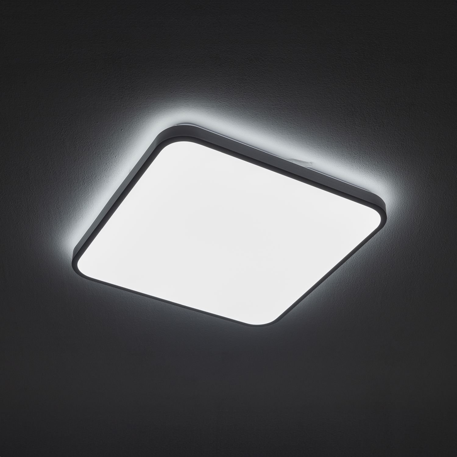 Kwadratowy plafon LED o nowoczesnym designie, emitujący jasne, równomierne światło. Lampa jest zamontowana na suficie, a jej krawędzie delikatnie rozświetlają otoczenie.
