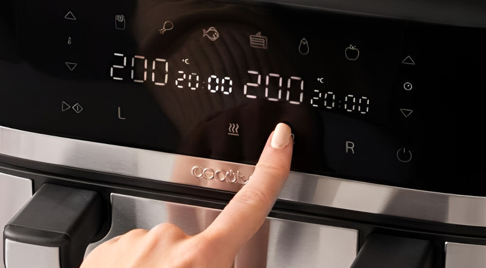 Panel sterowania frytkownicy z wyświetlaczem dotykowym pokazuje temperaturę 200°C i czas 20:00. Widoczna jest ręka dotykająca ekranu oraz logo \'cecotec\'.