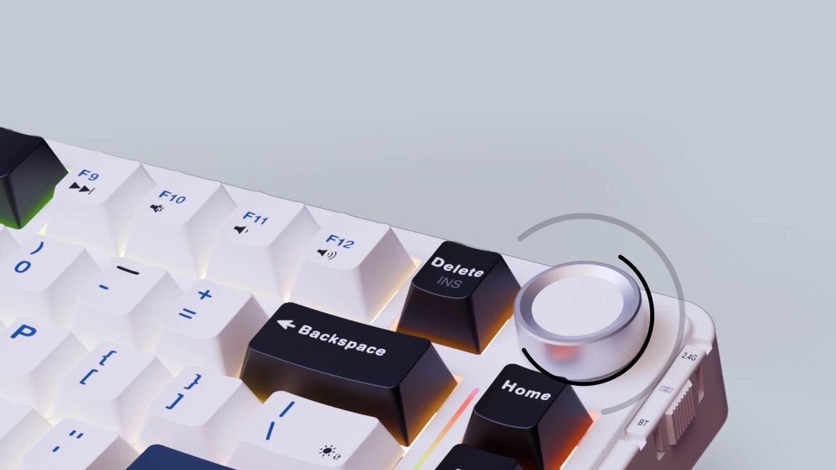 Fragment klawiatury z podświetlanymi klawiszami, w tym F9, F10, F11, F12, Backspace, Delete i Home. Obok klawisza Home znajduje się srebrne pokrętło.