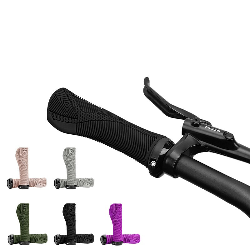 Na obrazie widoczne są czarne, ergonomiczne chwyty kierownicy z teksturowaną powierzchnią, zamontowane na rowerze z dźwignią hamulca oznaczoną logo \'Shimano\'. W dolnej części obrazu pokazano pięć dodatkowych wersji kolorystycznych chwytów: różową, szarą, zieloną, czarną i fioletową.