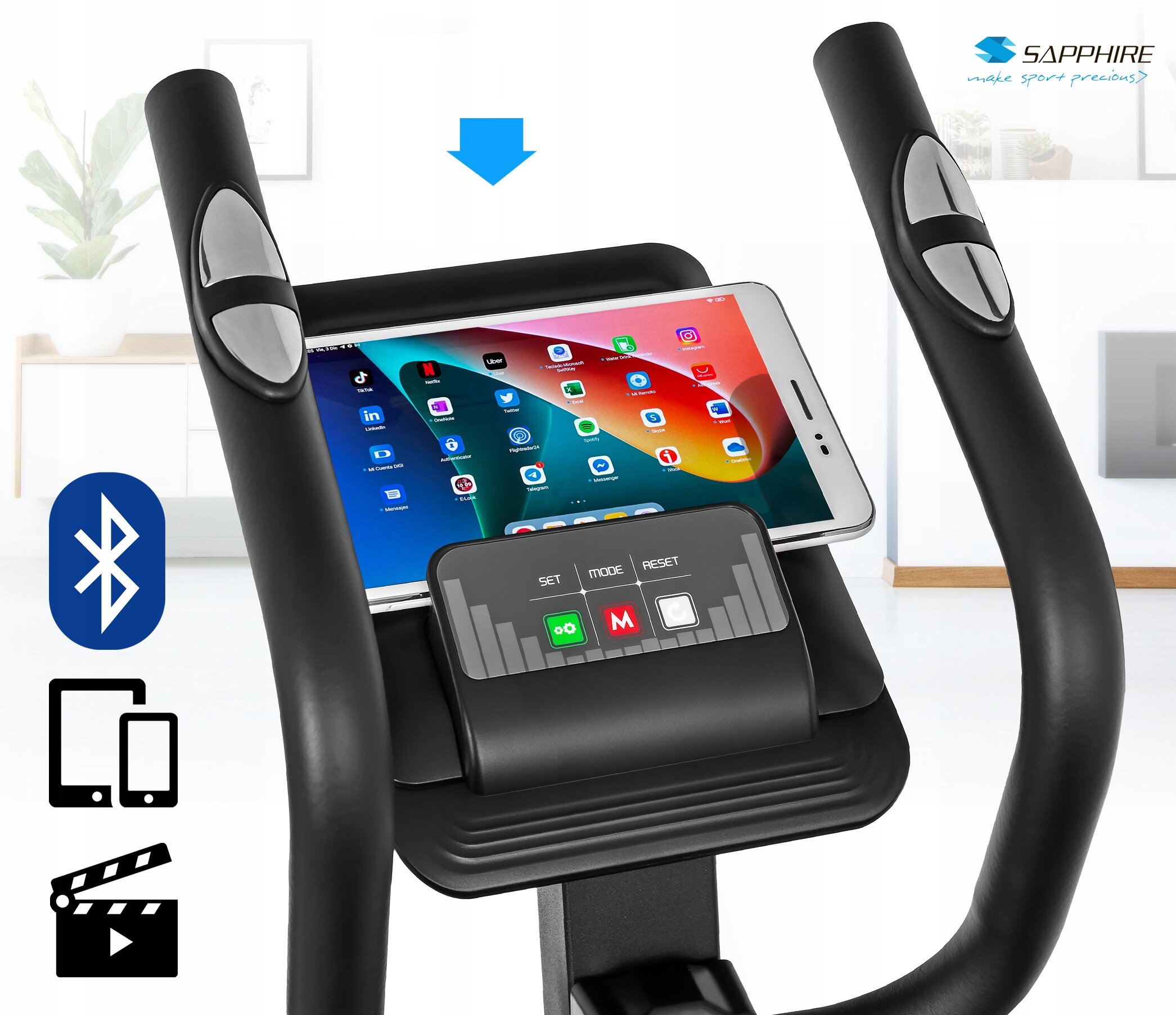 Na obrazie widoczny jest panel sterowania orbitreka z miejscem na tablet, na którym wyświetlone są aplikacje. Obok panelu znajdują się ikony Bluetooth, urządzeń mobilnych i filmu, a w górnym rogu logo \'SAPPHIRE make sport precious\'.