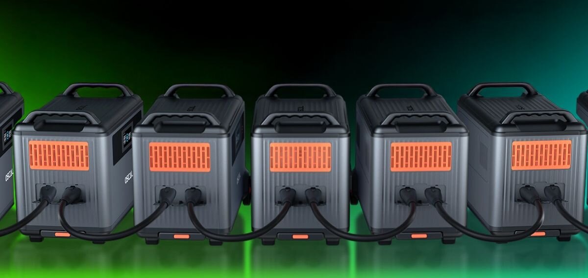 Stacja zasilania OSCAL PowerMax 6000 3600Wh, połączone, stacje, zielone, tło, Pięć stacji PowerMax 6000 połączonych przewodami na zielonym tle.