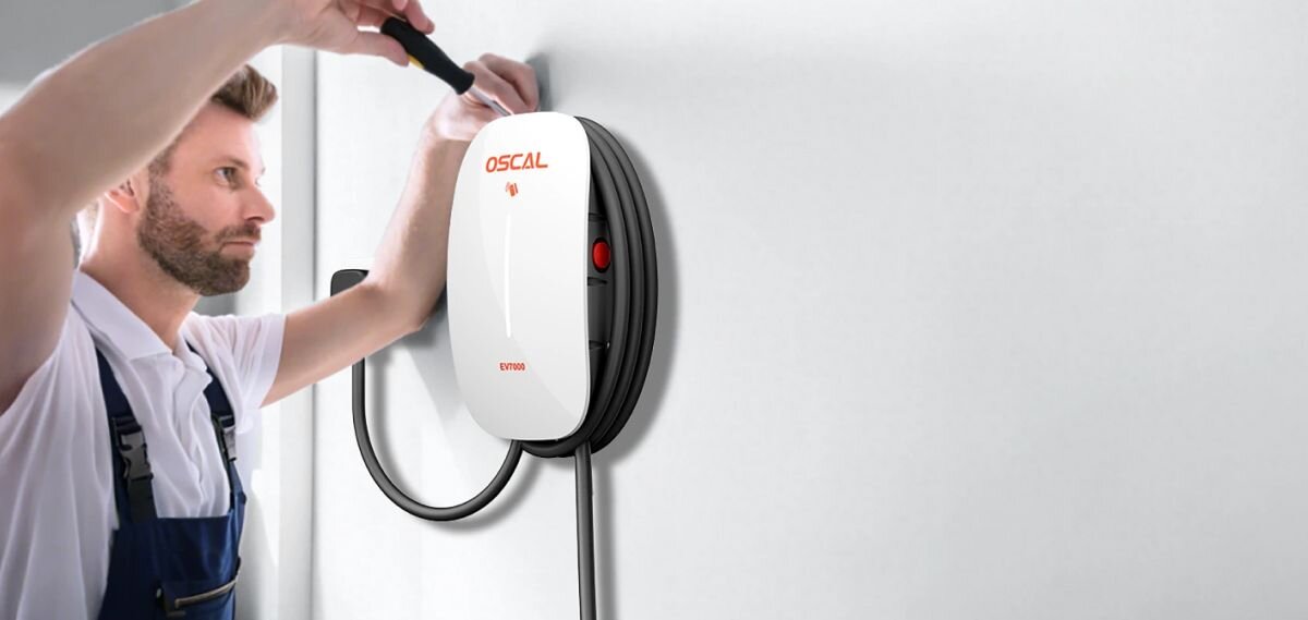 Ładowarka do samochodu elektrycznego OSCAL EV7000 7000W 32A, monter, ściana, narzędzie, instalacja, Monter przytrzymuje Oscal EV7000 na ścianie i dokręca mocowanie narzędziem.