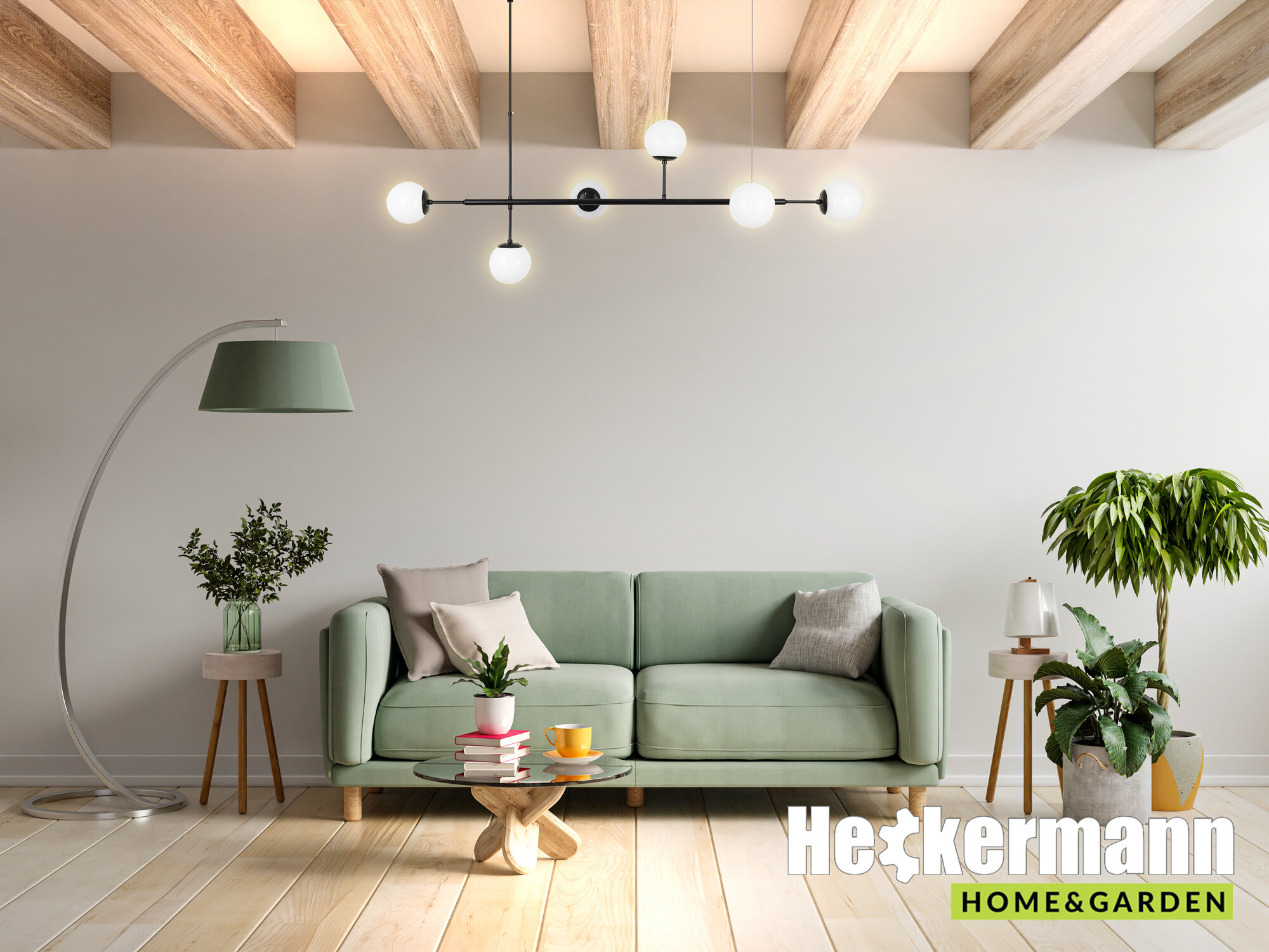 Wnętrze salonu z zieloną sofą, stolikiem kawowym i roślinami doniczkowymi. Na suficie wisi nowoczesna lampa z kilkoma żarówkami, a w rogu widoczne jest logo \'Heckermann Home & Garden\'.