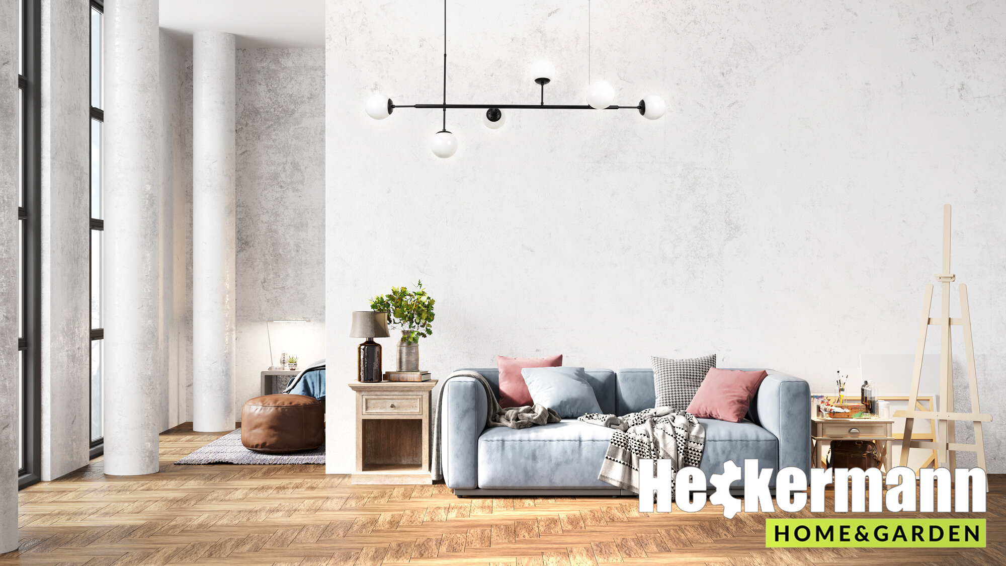 Wnętrze salonu z jasną sofą, stolikiem i dekoracjami, na suficie wisi nowoczesna lampa z czterema żarówkami. W prawym dolnym rogu widoczne jest logo \'Heckermann HOME & GARDEN\'.