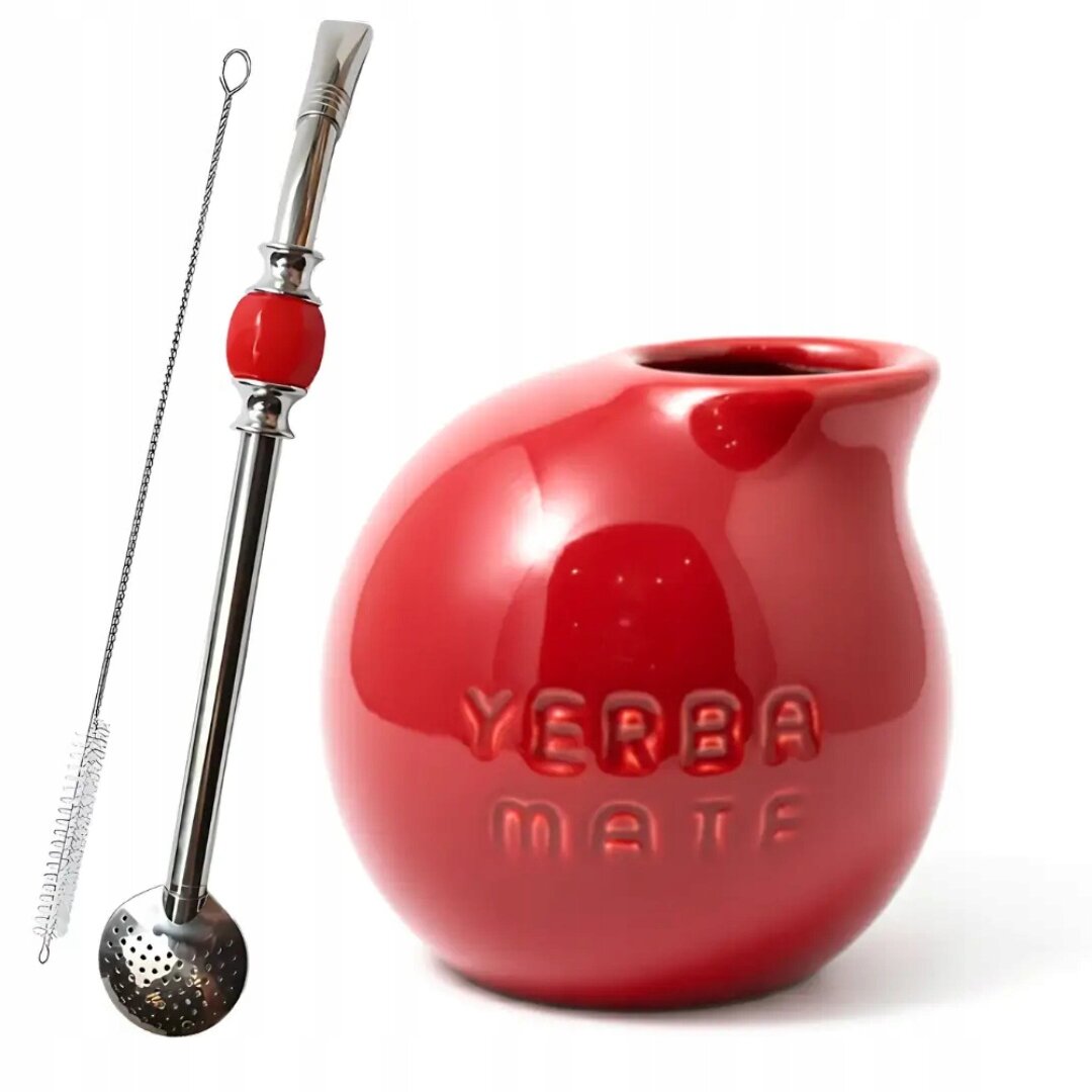 Na obrazie widoczny jest czerwony zestaw do yerba mate, składający się z matero w kształcie kuli z napisem \'YERBA MATE\' oraz metalowej bombilli z czerwonym elementem i sitkiem. Obok znajduje się szczoteczka do czyszczenia bombilli.