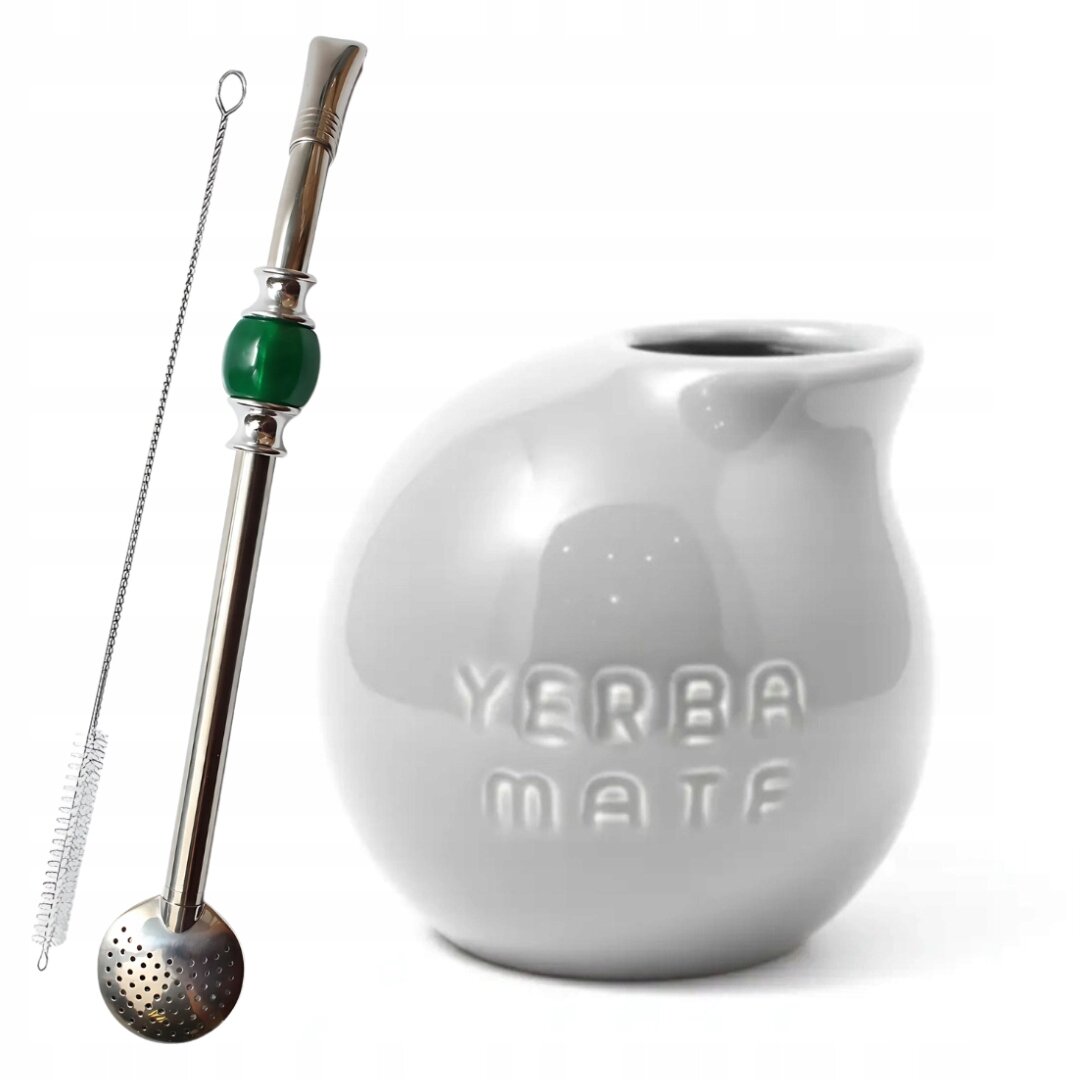 Na obrazie widoczny jest szary kubek z napisem \'YERBA MATE\' oraz metalowa bombilla z zielonym elementem i szczoteczką do czyszczenia.