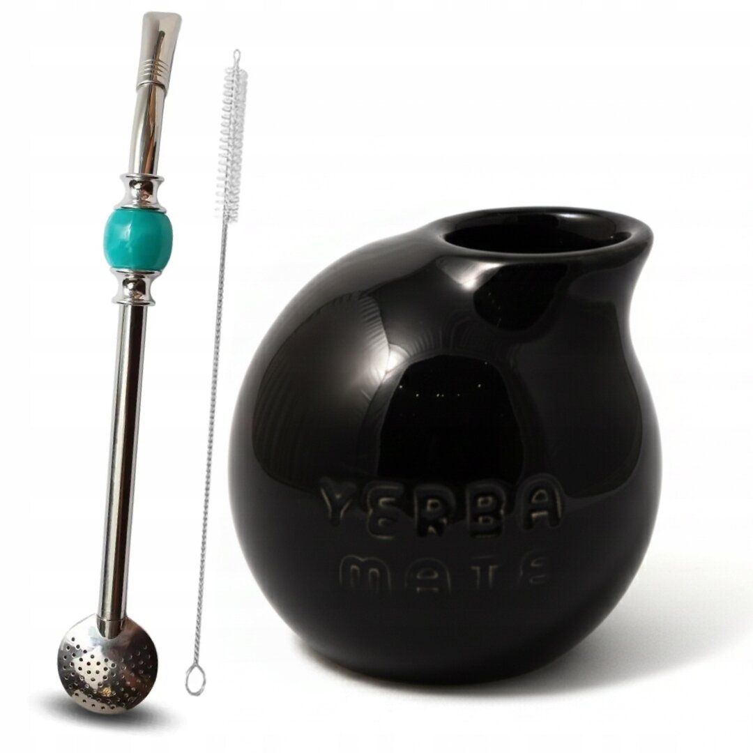 Na obrazie widoczny jest czarny kubek o kulistym kształcie z napisem \'Yerba Mate\' oraz metalowa bombilla z turkusowym elementem i szczoteczką do czyszczenia.