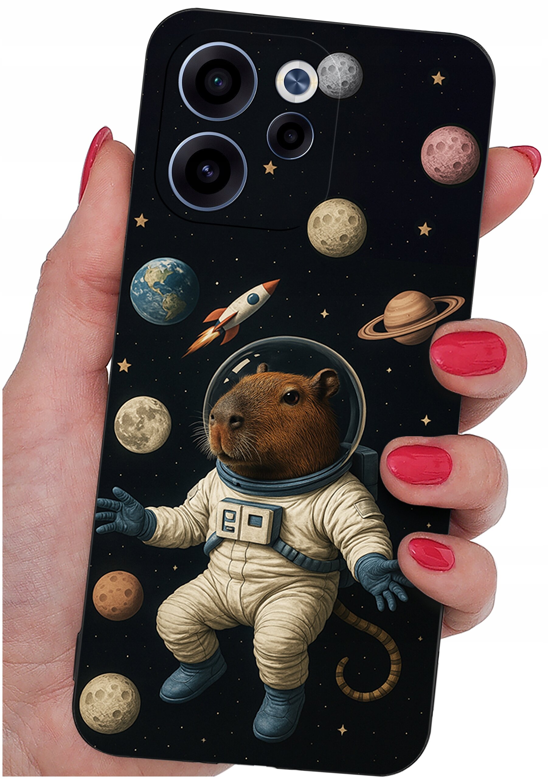 Etui na telefon z motywem kosmicznym, przedstawiające kapibarę w skafandrze astronauty otoczoną planetami i rakietą. Etui trzymane jest w dłoni z pomalowanymi na czerwono paznokciami.