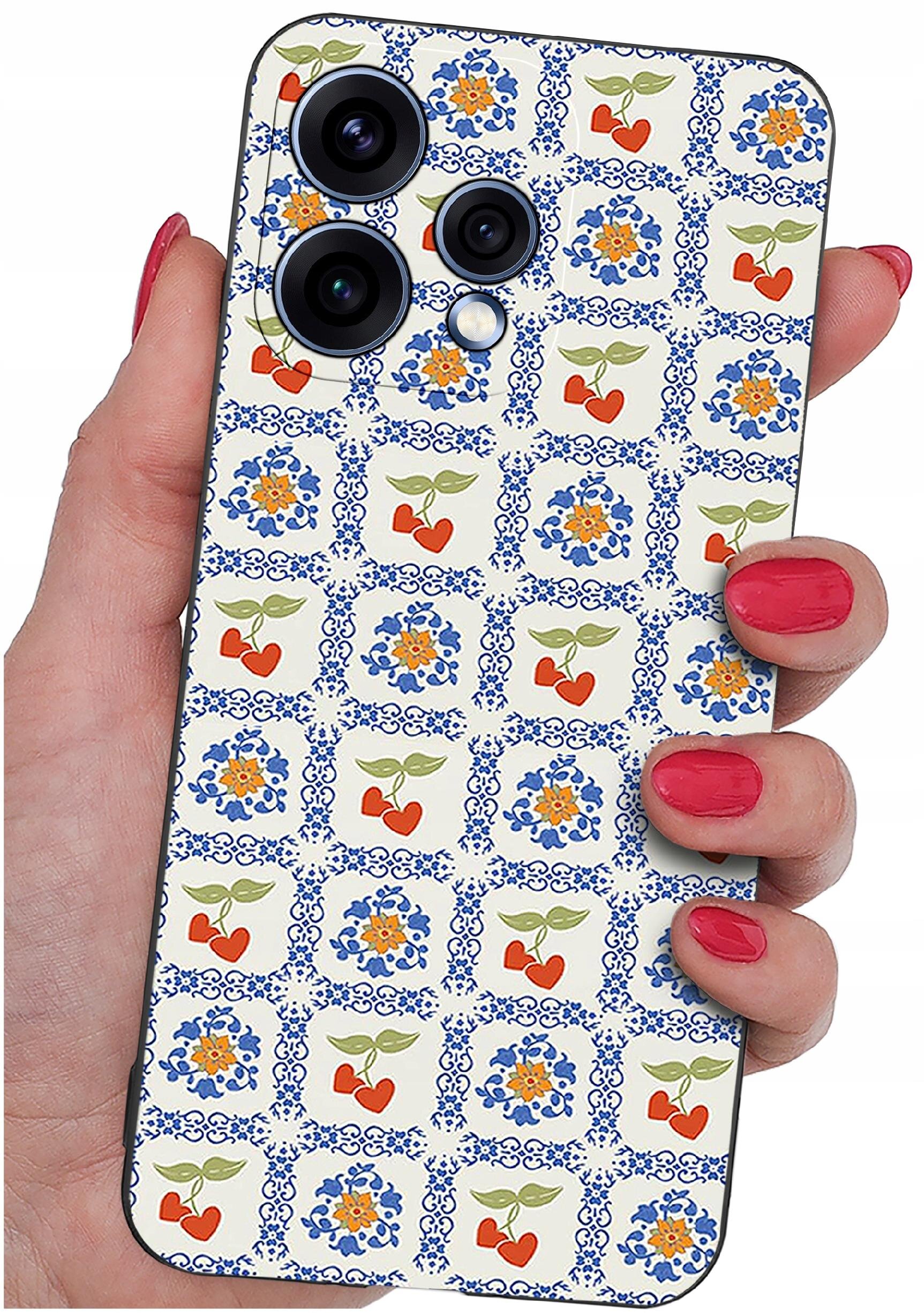 Osoba trzyma telefon z etui ozdobionym wzorem w niebieskie i pomarańczowe kwiaty oraz czerwone serca z zielonymi liśćmi. Etui ma trzy widoczne obiekty przypominające obiektywy aparatu.
