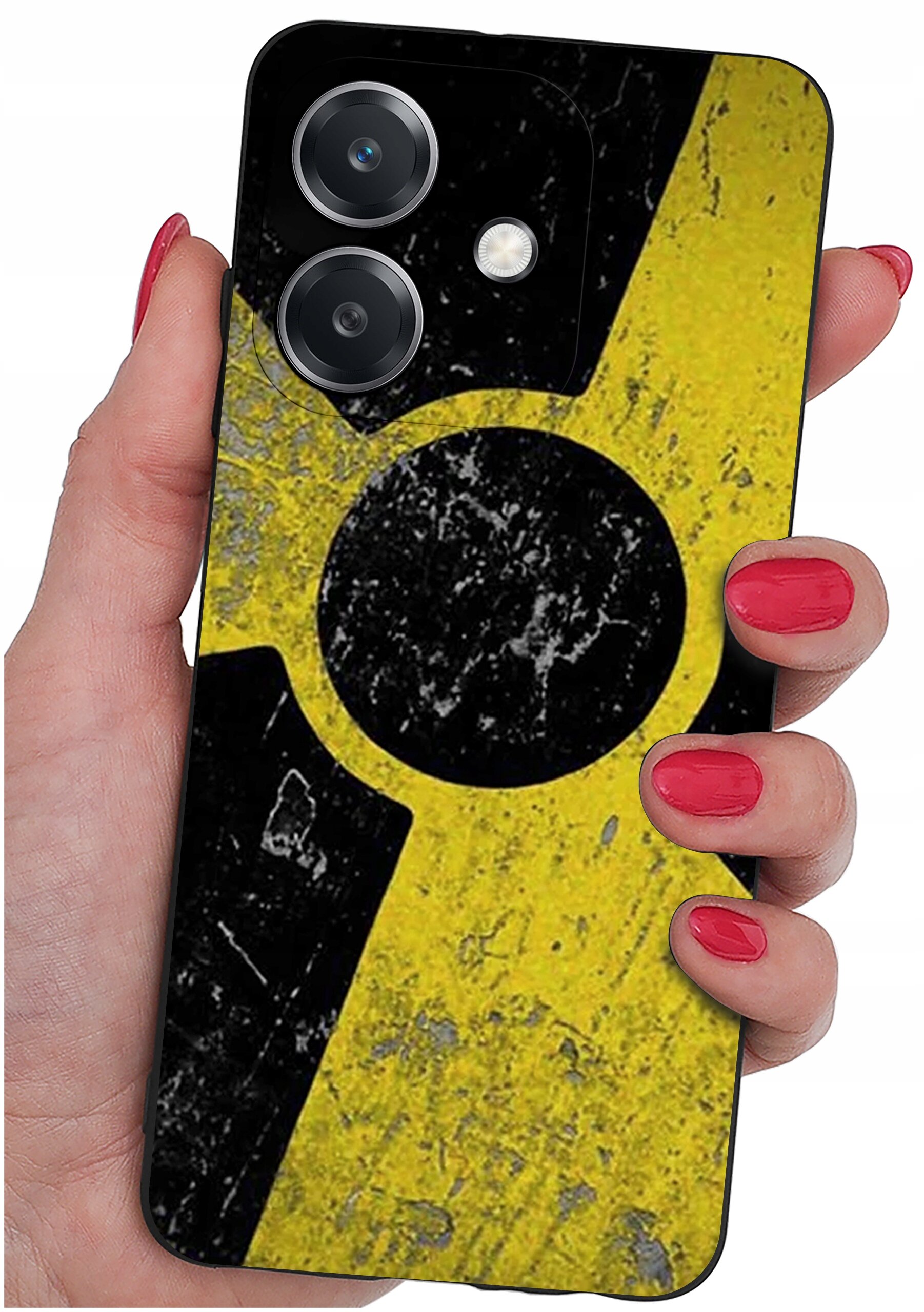Osoba trzyma telefon z etui o wzorze przypominającym znak ostrzegawczy z czarnym okręgiem na żółtym tle. Etui ma wycięcia na dwa obiektywy aparatu i lampę błyskową.
