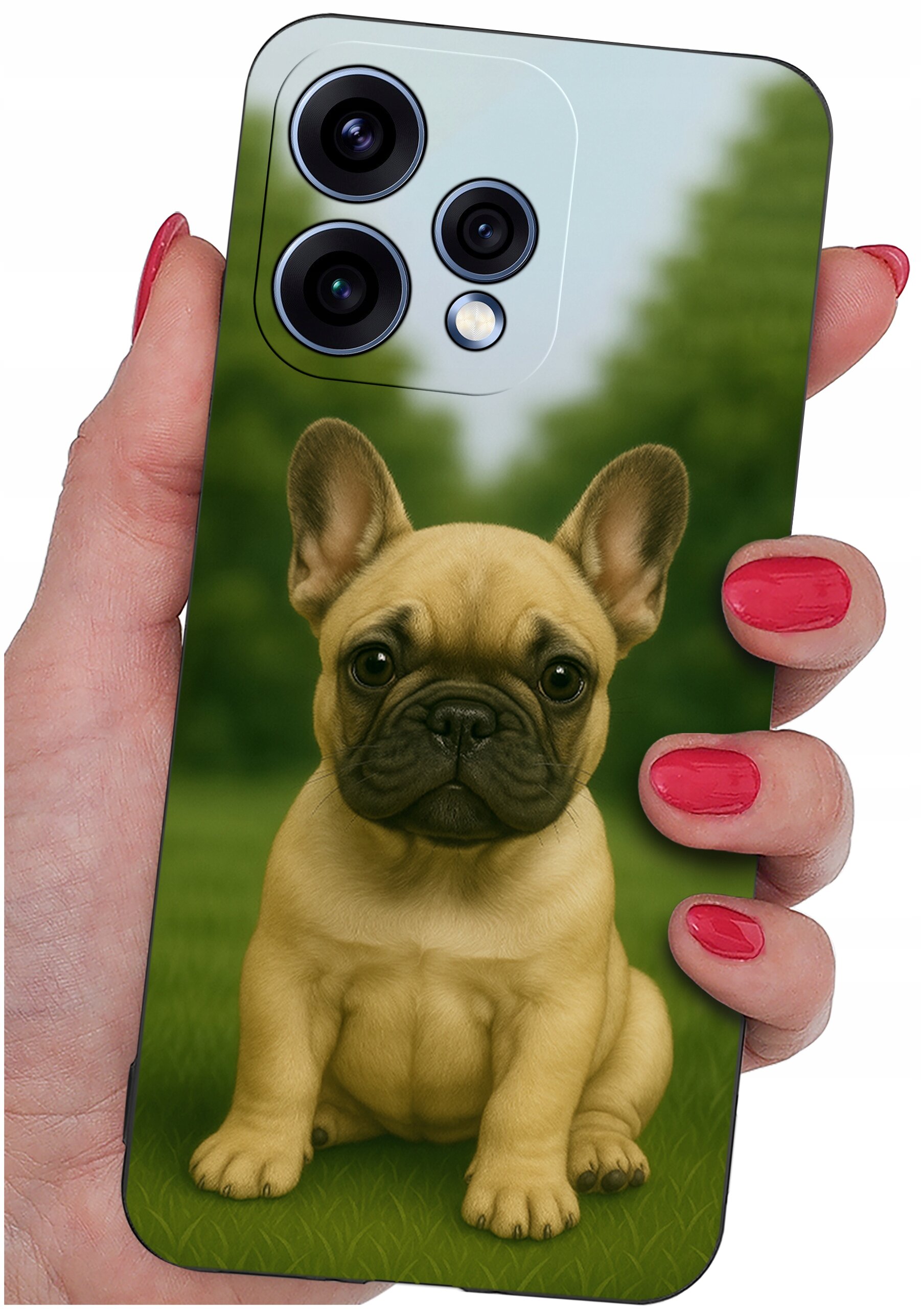 Etui na telefon z nadrukiem psa, trzymane w dłoni z pomalowanymi na czerwono paznokciami. W tle widoczny jest rozmyty krajobraz z zielenią.