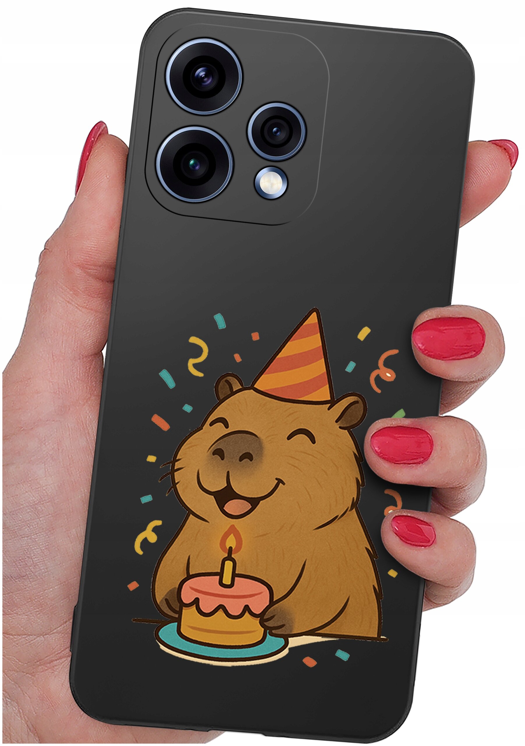 Osoba trzyma telefon z czarnym etui, na którym znajduje się rysunek uśmiechniętej kapibary w czapeczce imprezowej, trzymającej tort z zapaloną świeczką. W tle widać kolorowe konfetti.