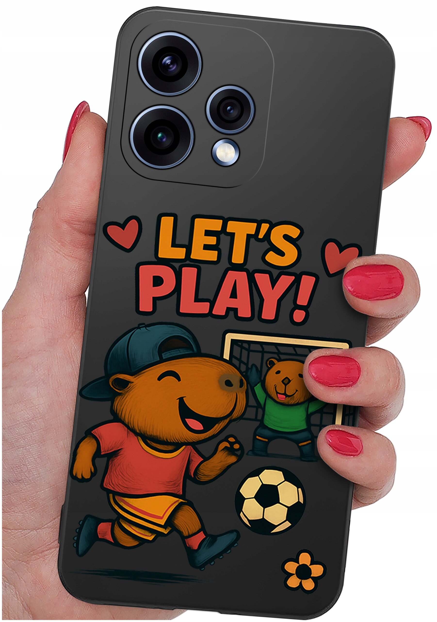 Etui na telefon z grafiką przedstawiającą zwierzęta grające w piłkę nożną oraz napis \'LET\'S PLAY!\'. Etui trzymane jest w dłoni z pomalowanymi na czerwono paznokciami.