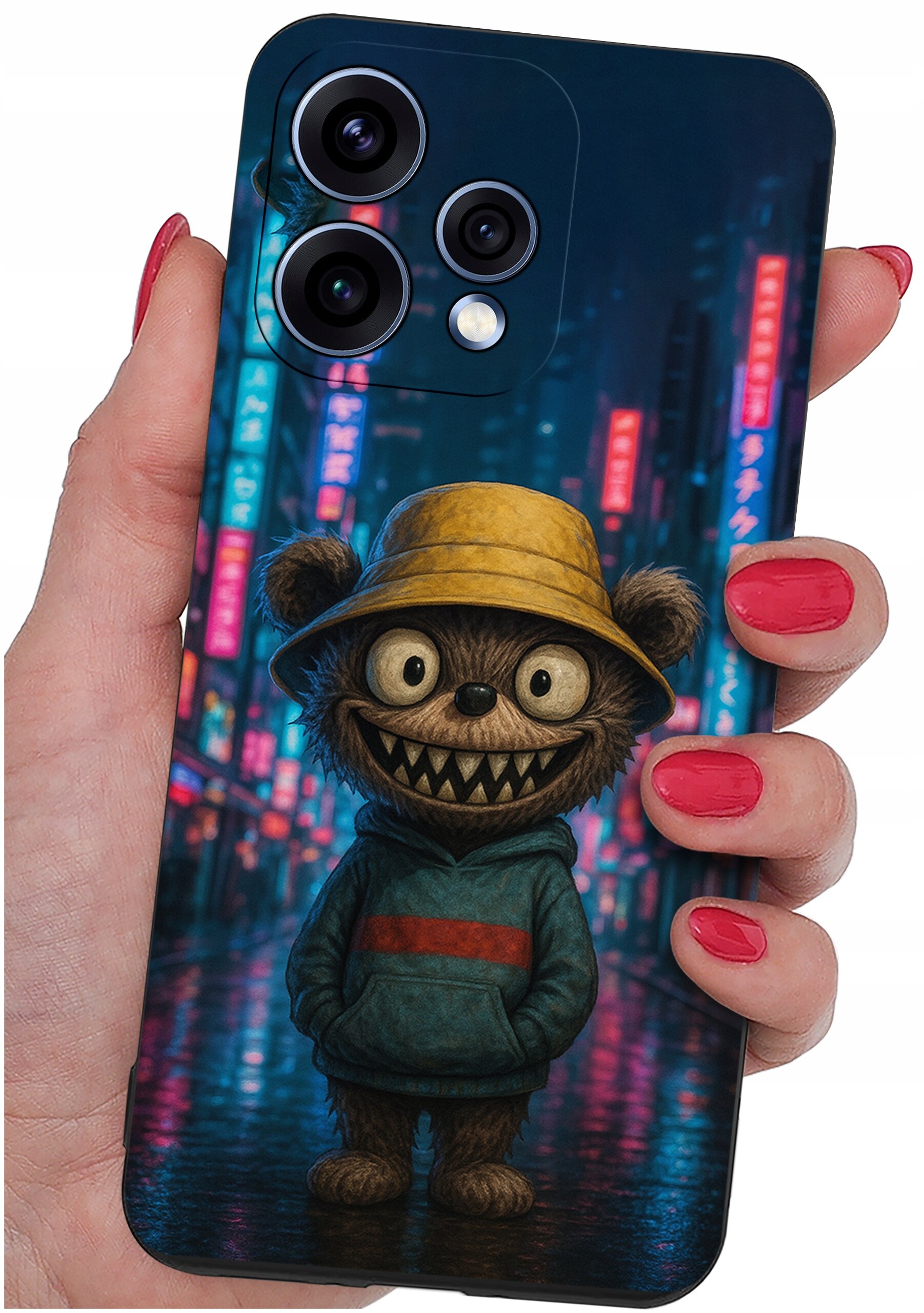 Etui na telefon z nadrukiem postaci przypominającej misia w żółtym kapeluszu i niebieskiej bluzie, trzymane w dłoni z pomalowanymi na czerwono paznokciami. W tle widoczne są rozmyte, kolorowe światła miasta.