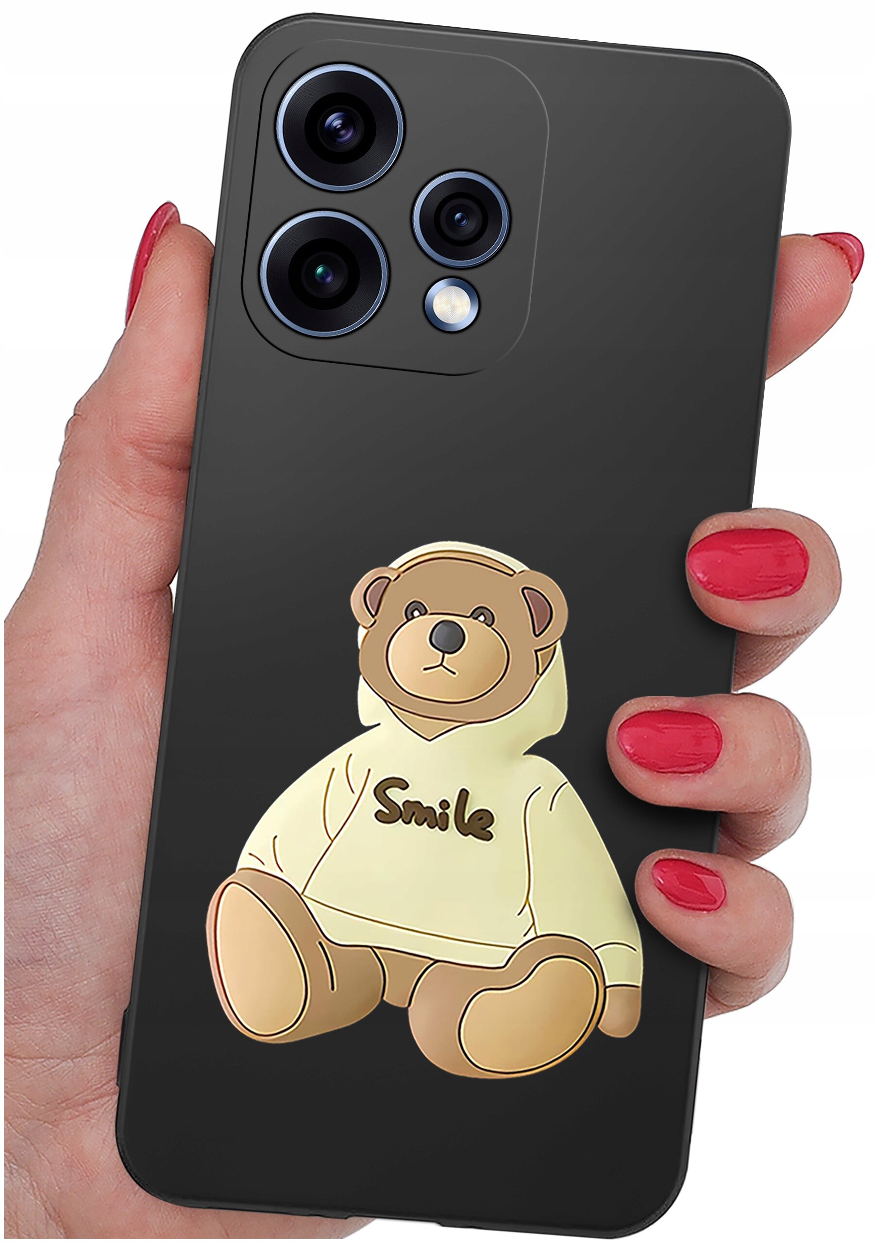 Czarna obudowa telefonu z nadrukiem misia w bluzie z napisem \'Smile\'. Obudowa jest trzymana w dłoni z pomalowanymi na czerwono paznokciami.