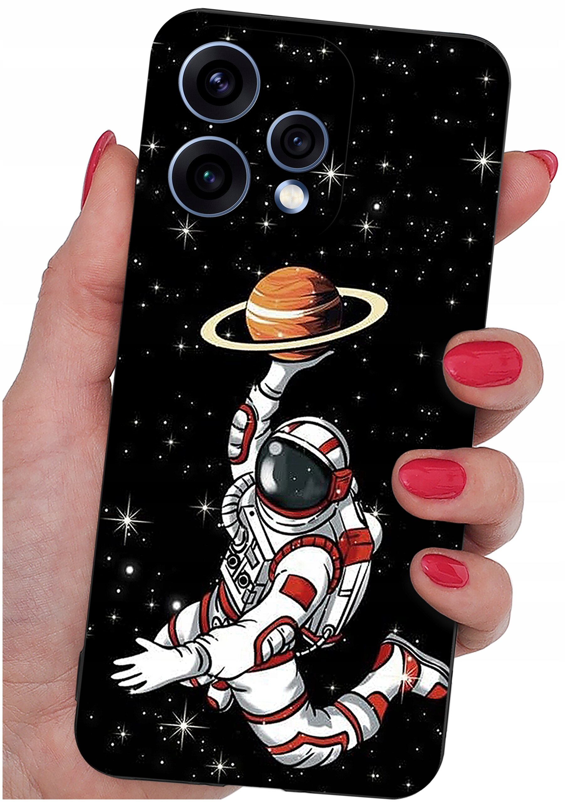 Etui na telefon z grafiką przedstawiającą astronautę unoszącego planetę z pierścieniami na tle gwiazd. Etui trzymane jest w dłoni z pomalowanymi na czerwono paznokciami.