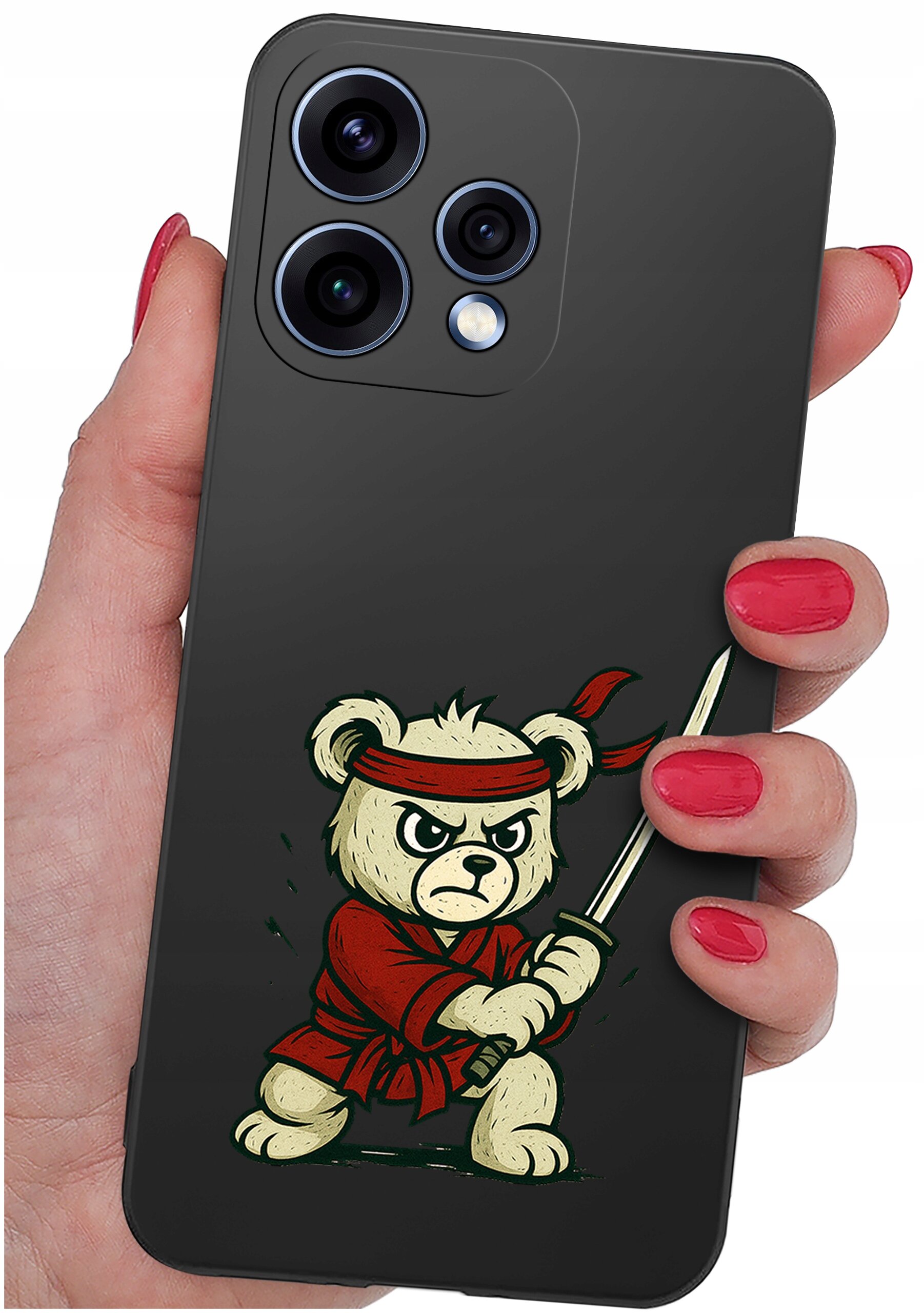 Osoba trzyma telefon z czarnym etui, na którym znajduje się rysunek misia w czerwonym stroju z mieczem. Etui ma wycięcia na trzy obiektywy aparatu i lampę błyskową.