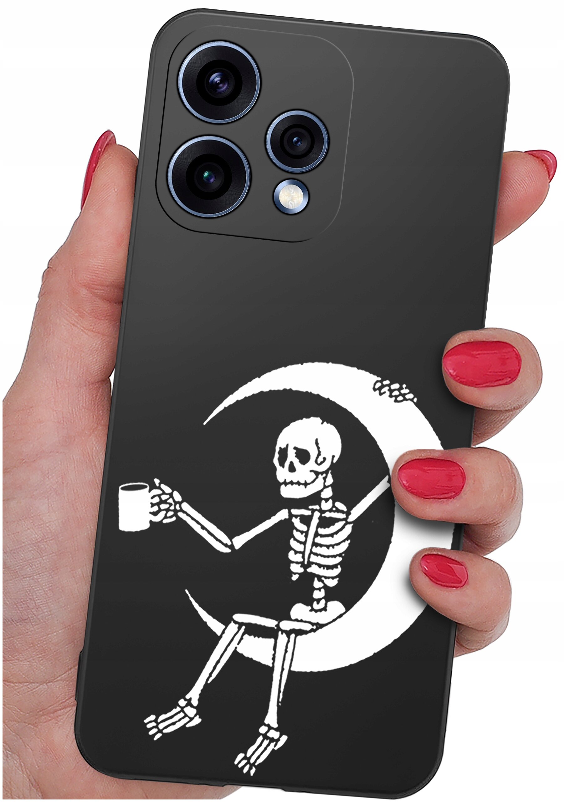 Czarne etui na telefon z nadrukiem białego szkieletu siedzącego na księżycu, trzymającego kubek. Etui jest trzymane w dłoni z pomalowanymi na czerwono paznokciami.