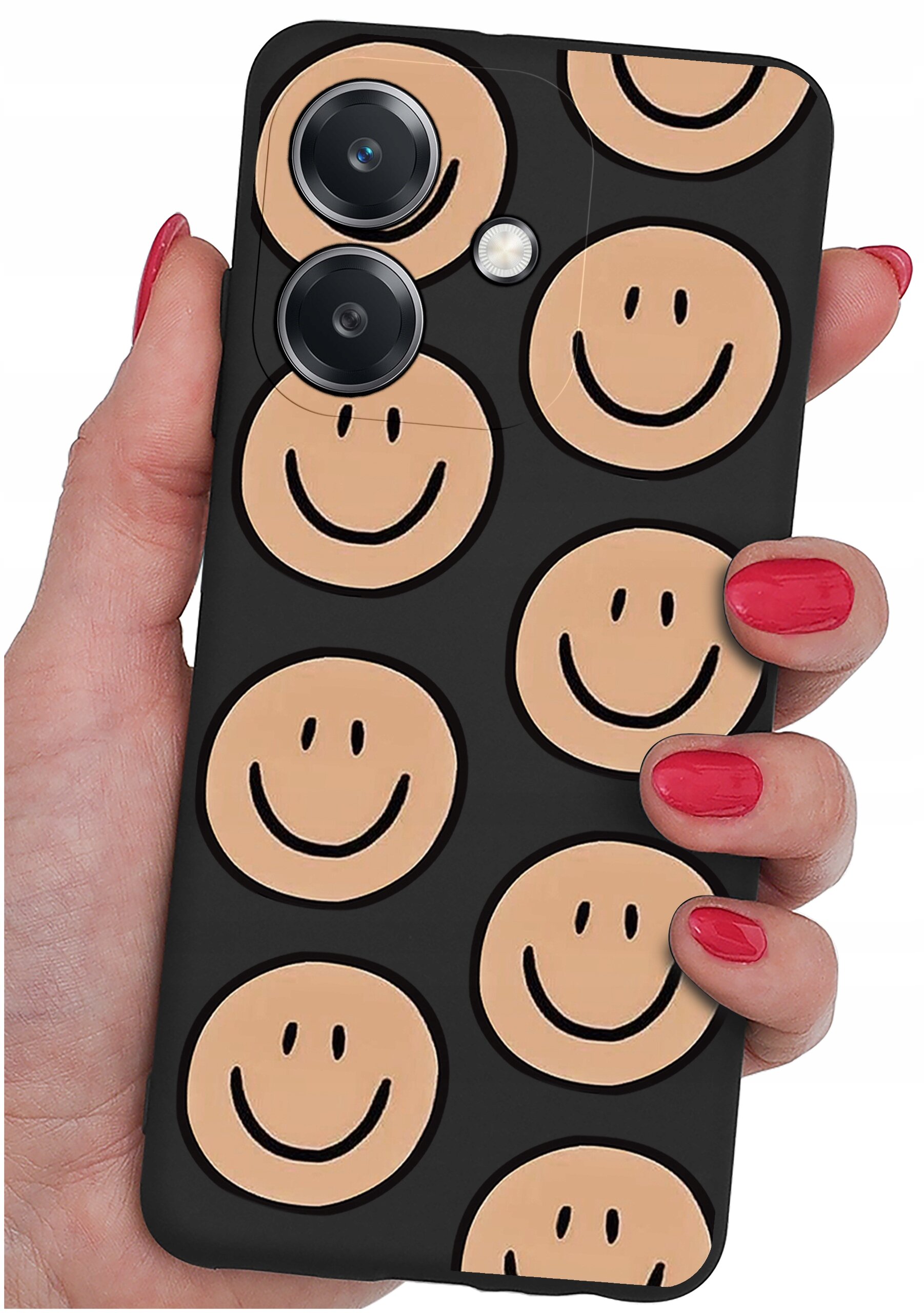 Osoba trzyma telefon z etui ozdobionym wzorem uśmiechniętych buziek na czarnym tle. Etui ma wycięcia na trzy obiektywy aparatu.