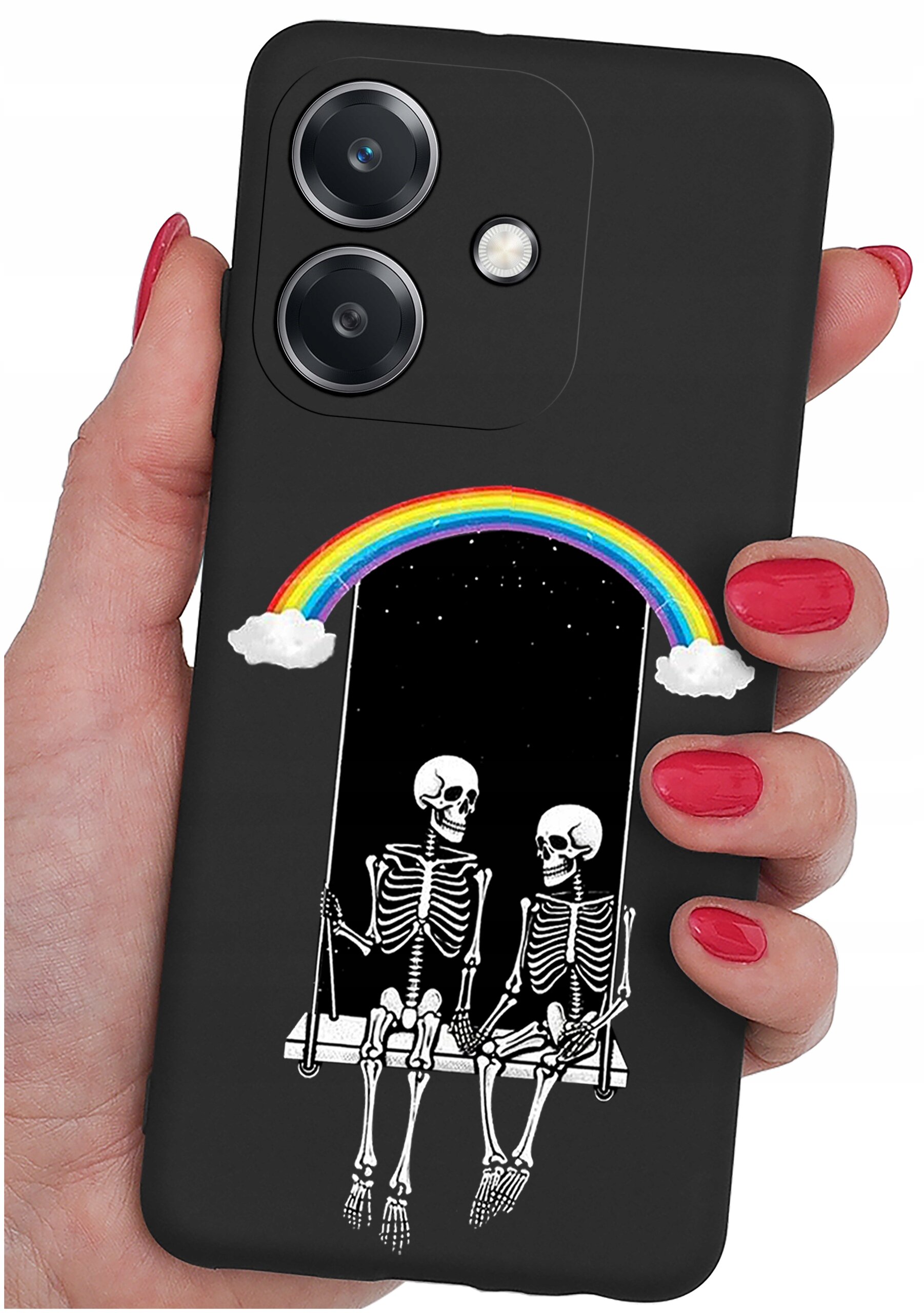 Czarne etui na telefon z grafiką przedstawiającą dwa szkielety siedzące na huśtawce pod tęczą. Etui trzymane jest w dłoni z pomalowanymi na czerwono paznokciami.